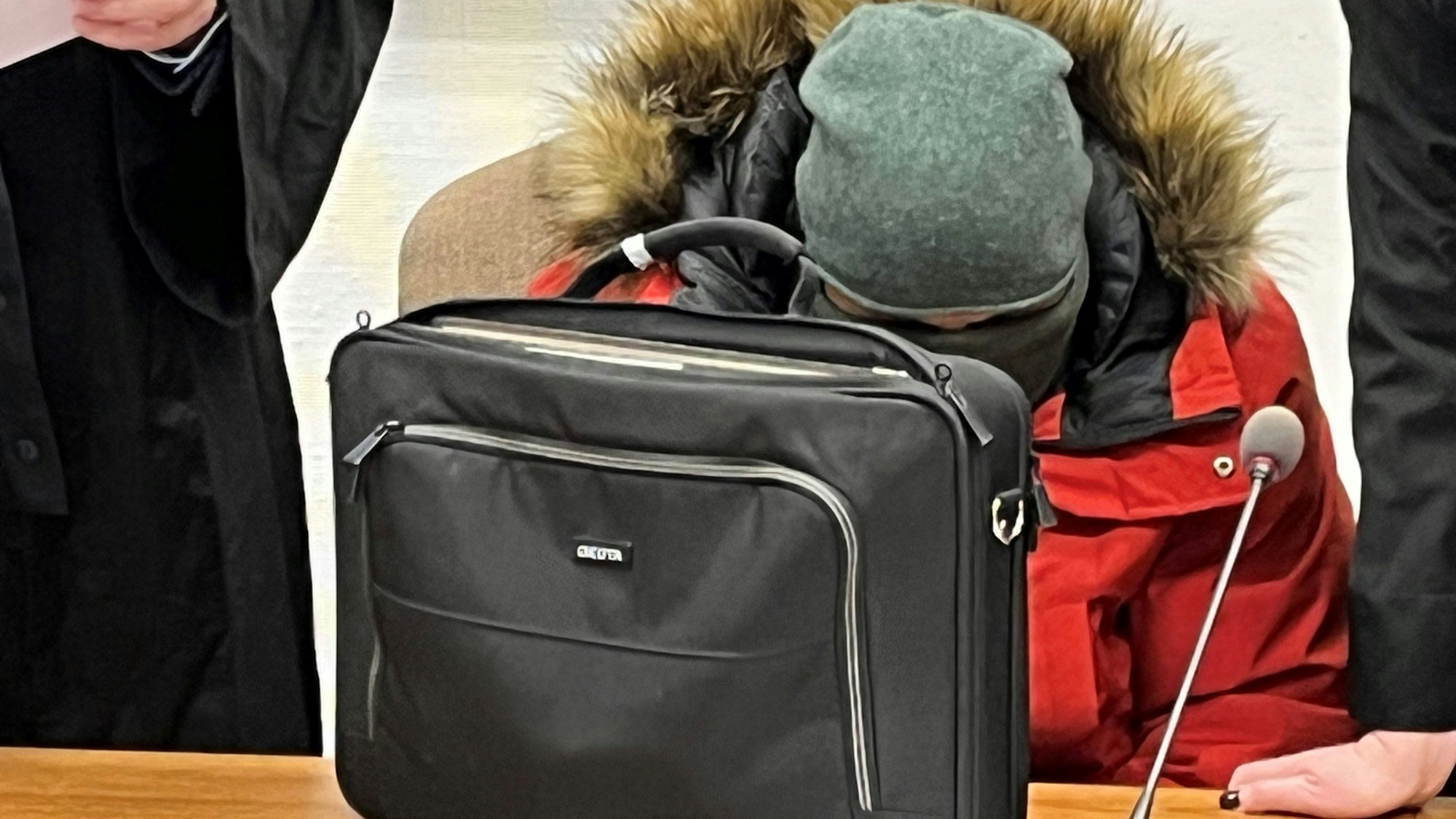 Der 38-jährige Kerpener versteckte sich beim Prozessauftakt am 29. Januar 2024  vermummt hinter einer Laptoptasche.