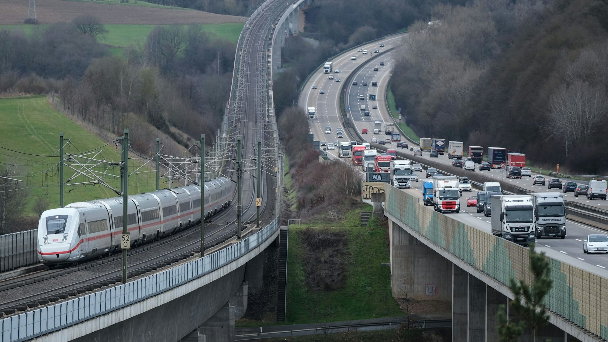 Ein ICE der Deutschen Bahn (l) fährt auf der Strecke Köln Frankfurt in Richtung Frankfurt/Main neben der Autobahn A3 (r) über die Wiedttalbrücke.