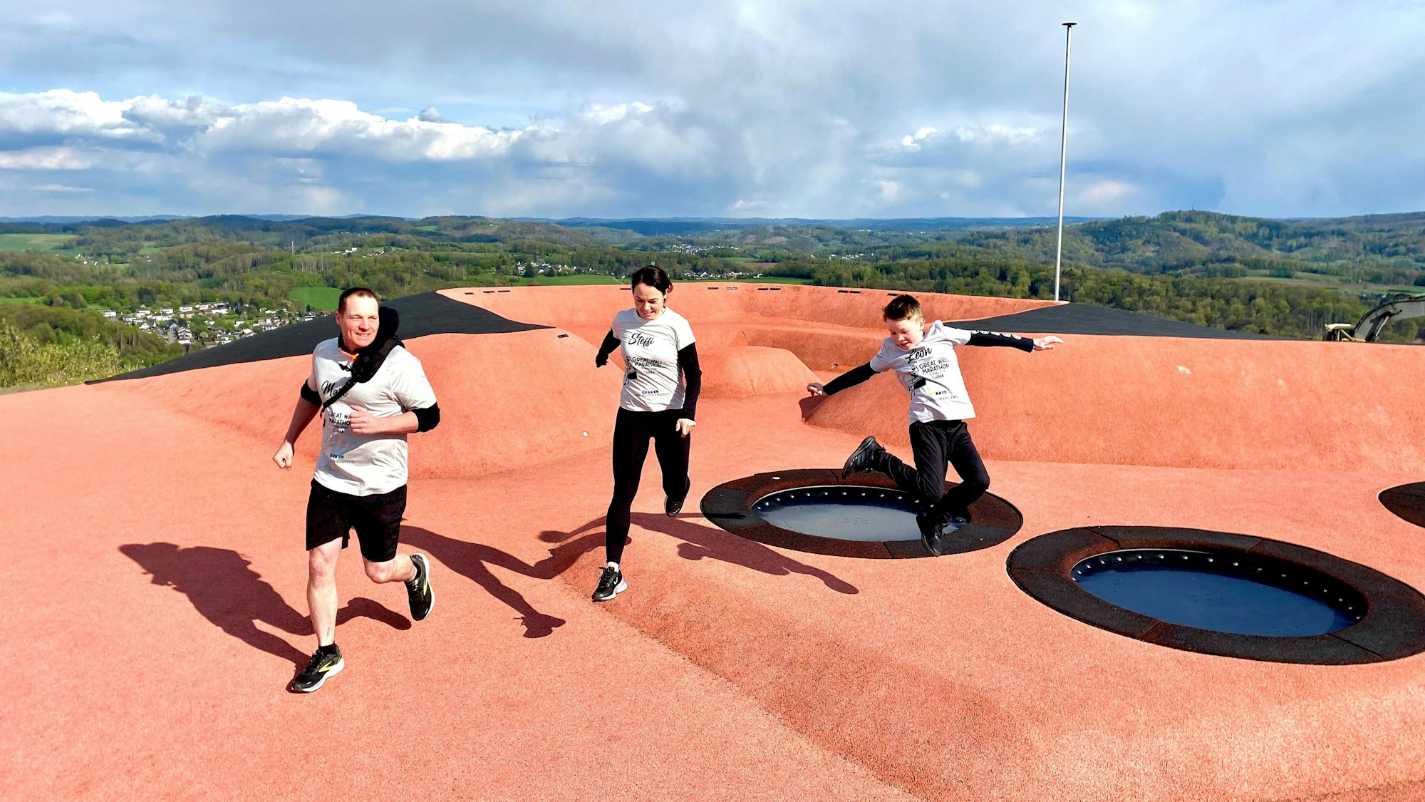 Auf der Spitze des Metabolons rennt die Familie über einen roten Tartan-Platz.