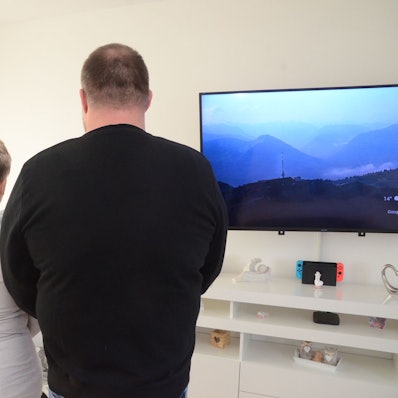 Ein Mann und eine Frau blicken in Richtung einer Wand.