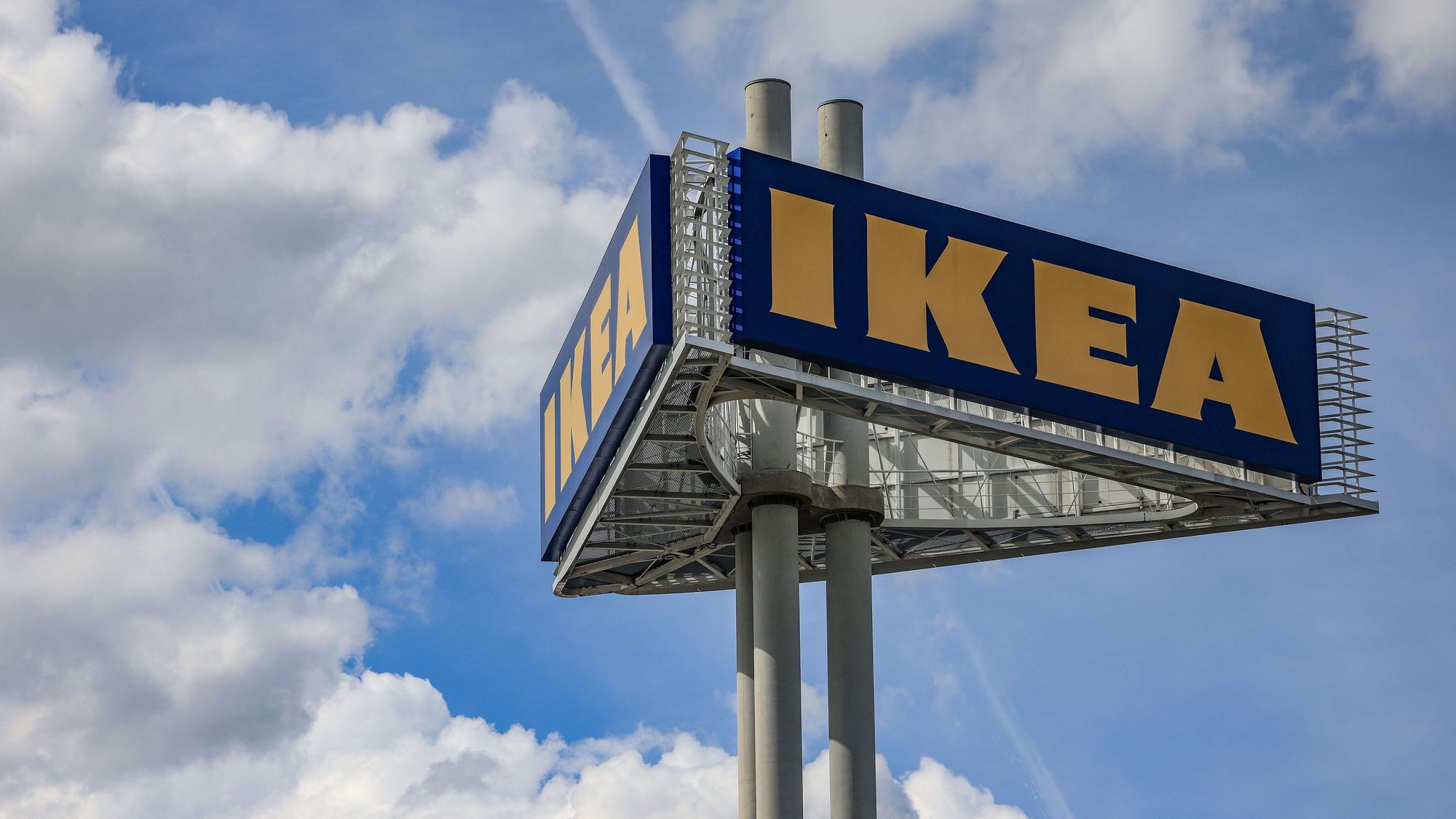 Ein Firmenlogo steht vor der Ikea-Filiale Köln Godorf.