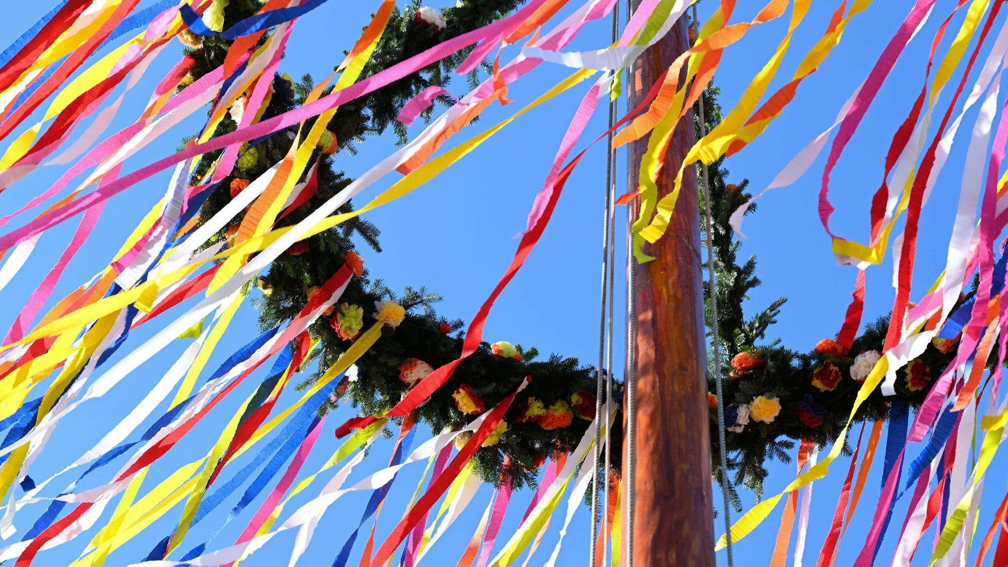 Der Kranz des eines Maibaums weht im Wind.