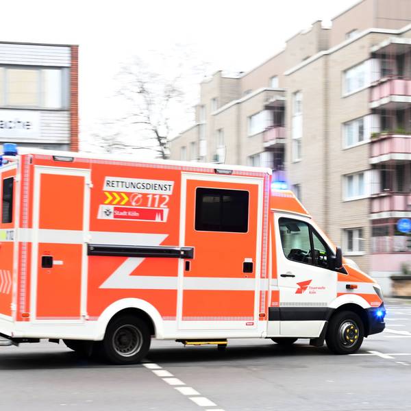 Ein Feuerwehrauto fährt über eine ansonsten leere Straße.