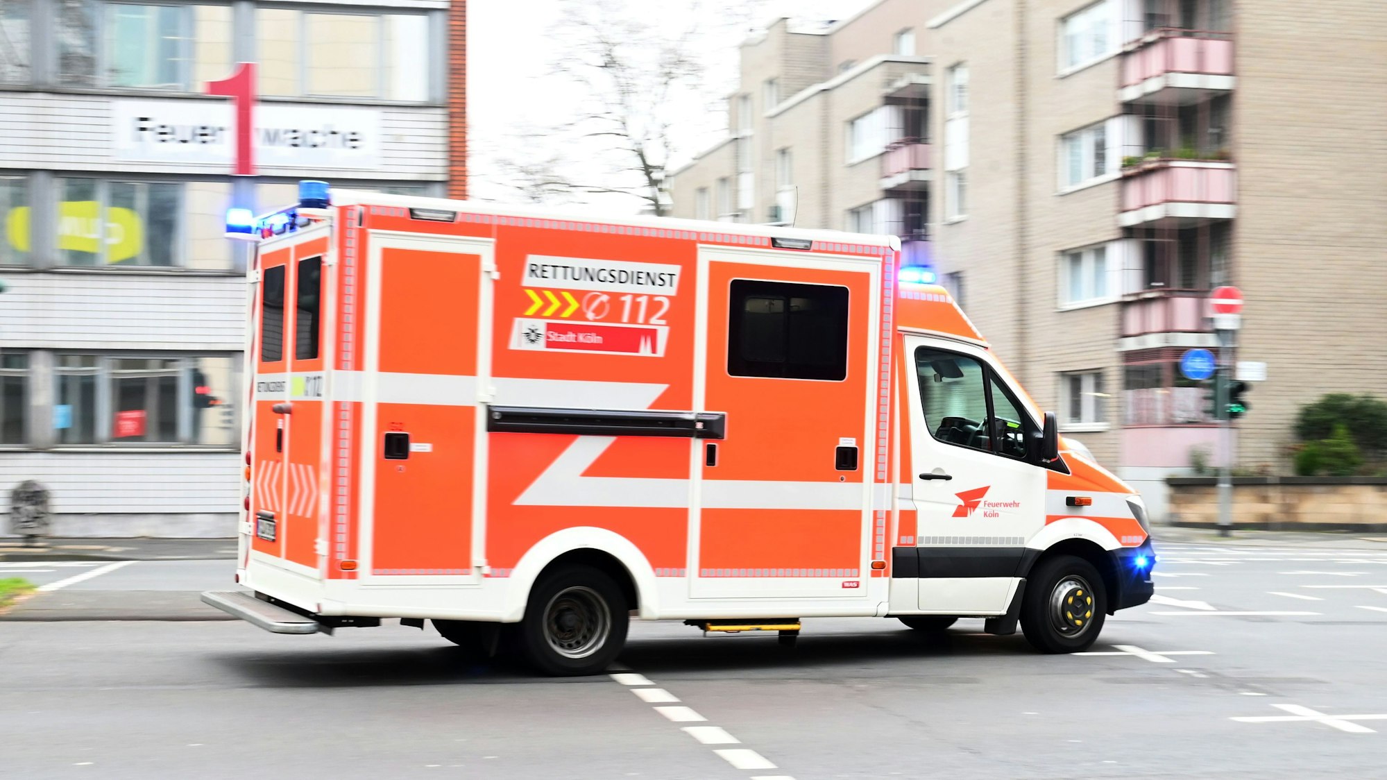Ein Feuerwehrauto fährt über eine ansonsten leere Straße.