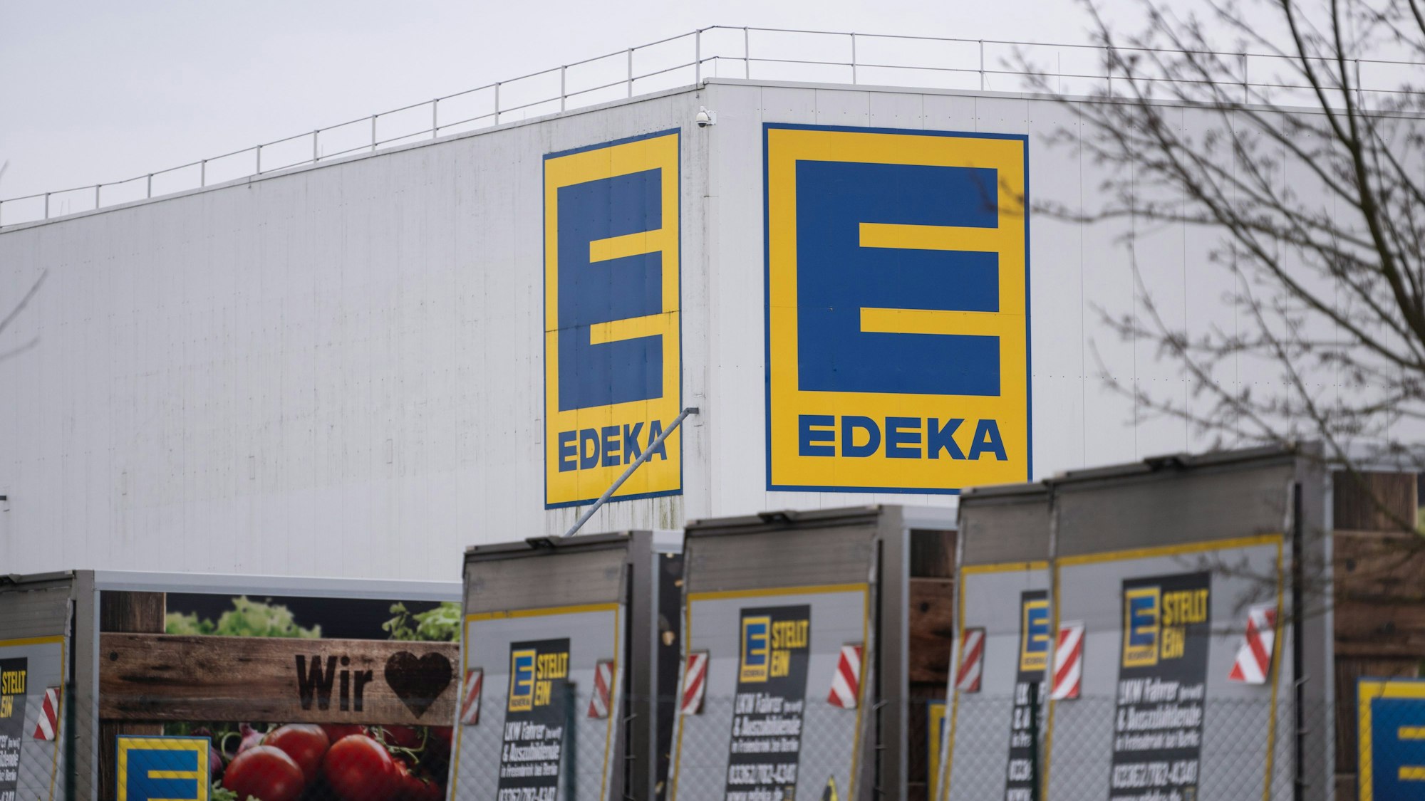 Vor einem Logistikzentrum der Handelskette Edeka stehen mehrere LKW. (Archivbild)