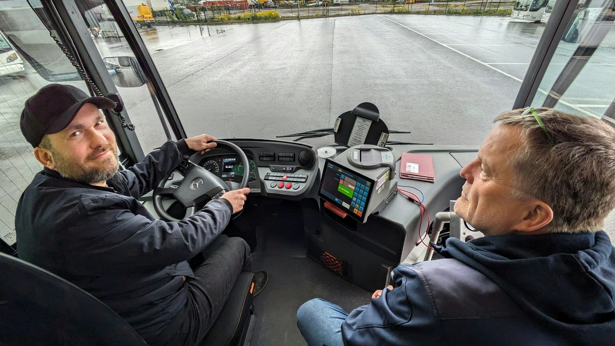 Ein Bewerber und der Fahrlehrer sitzen im Cockpit eines Gelenkbusses.