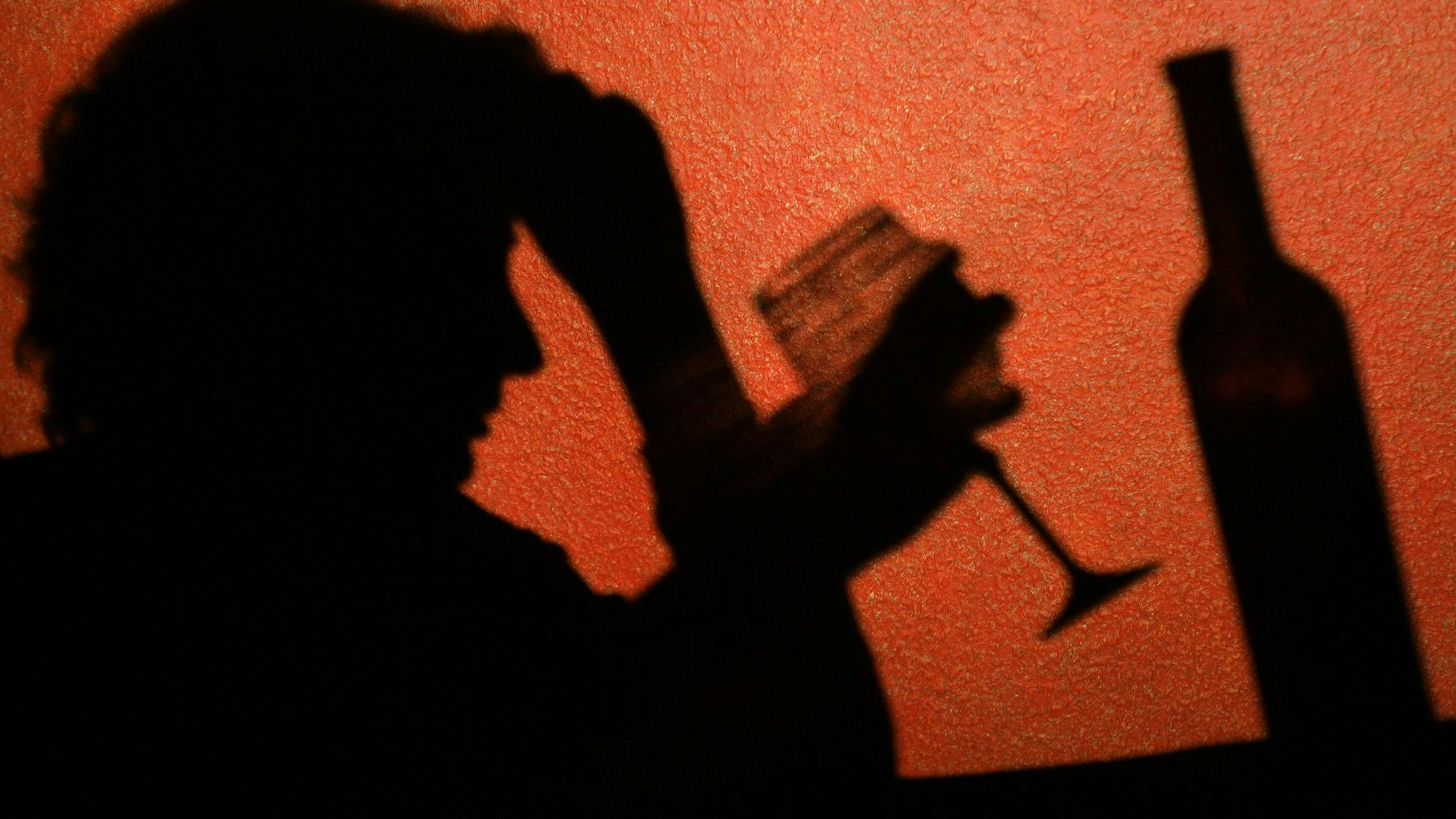 Der Schatten einer Frau, die ein Glas Wein trinkt, ist an der Wand in einer Kneipe in Frankfurt (Oder) zu erkennen. Laut einer aktuellen Studie sterben Alkoholabhängige deutlich früher.