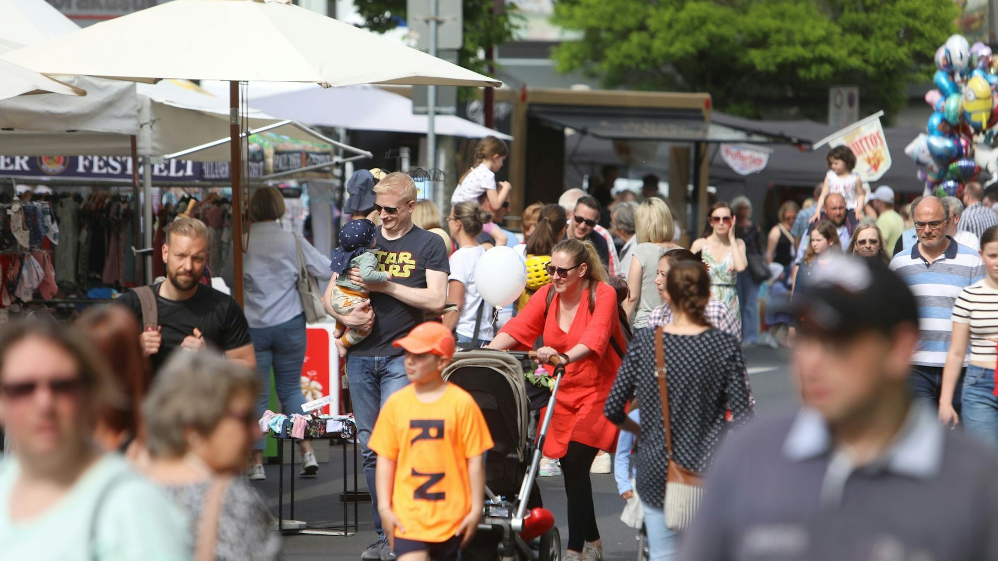 Menschen schlendern über eine Einkaufstraße.