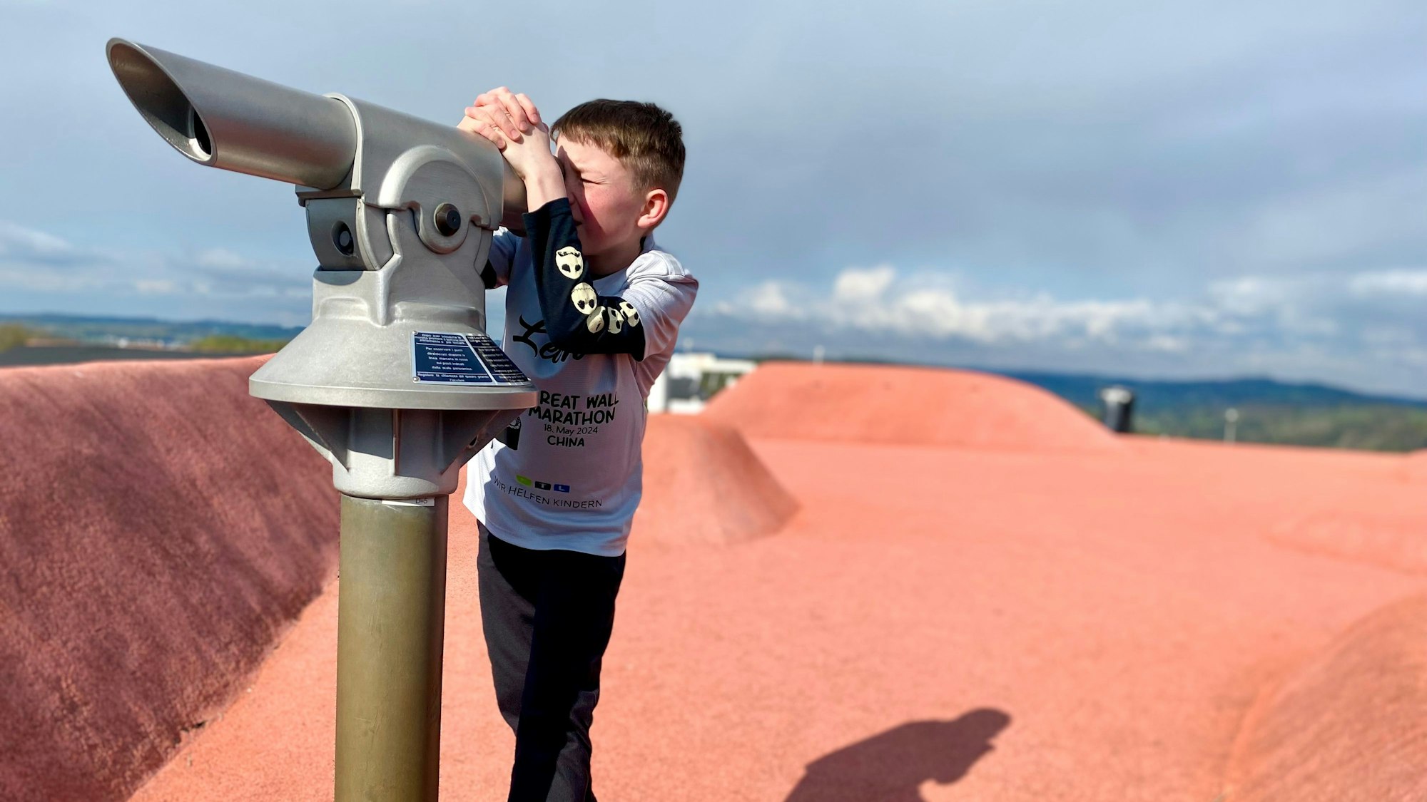 Leon guckt durch ein Fernrohr.