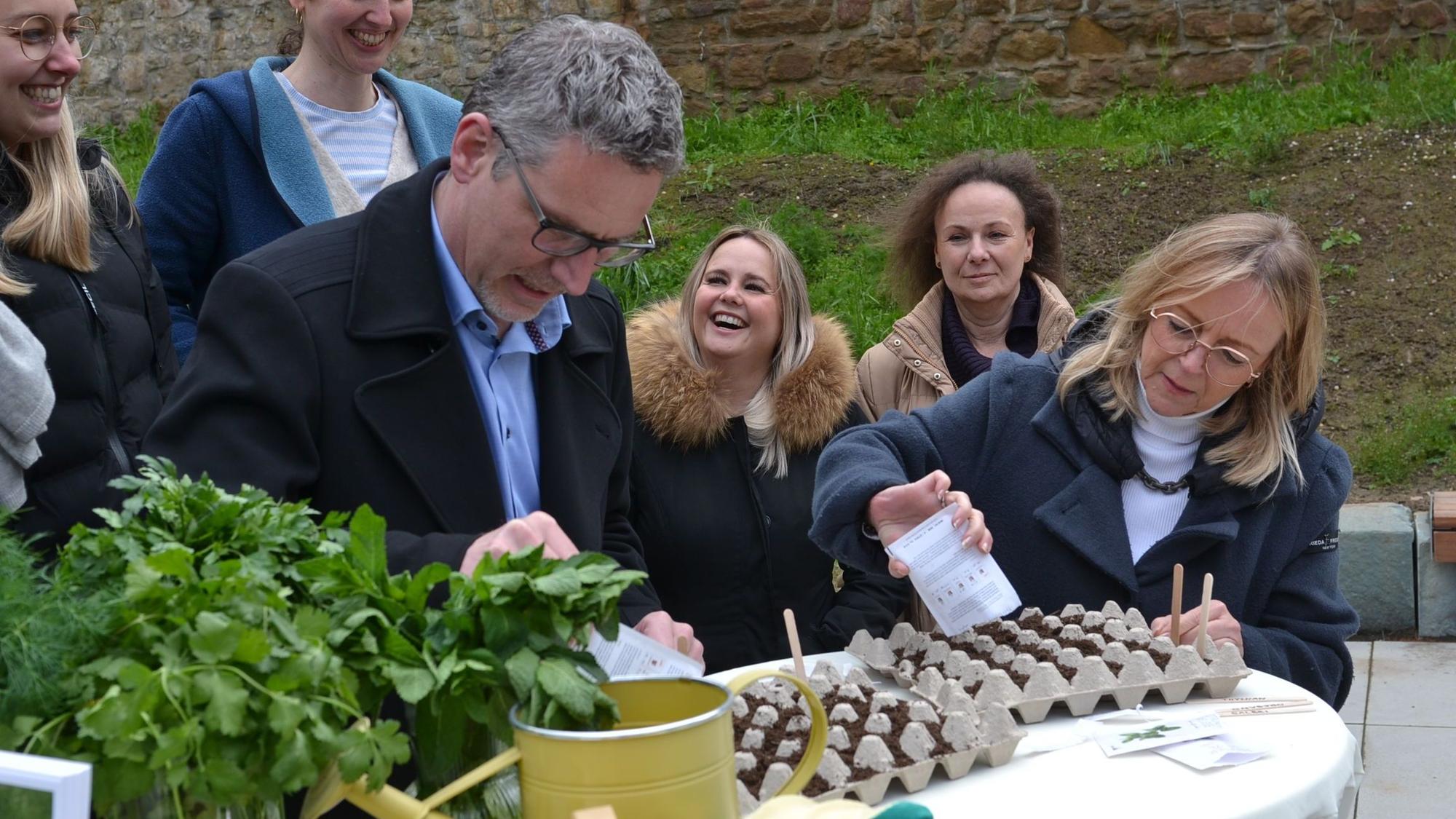 Sabine Preiser-Marian und Norbert Crump schütten Pflanzensamen in einen Eierkarton.