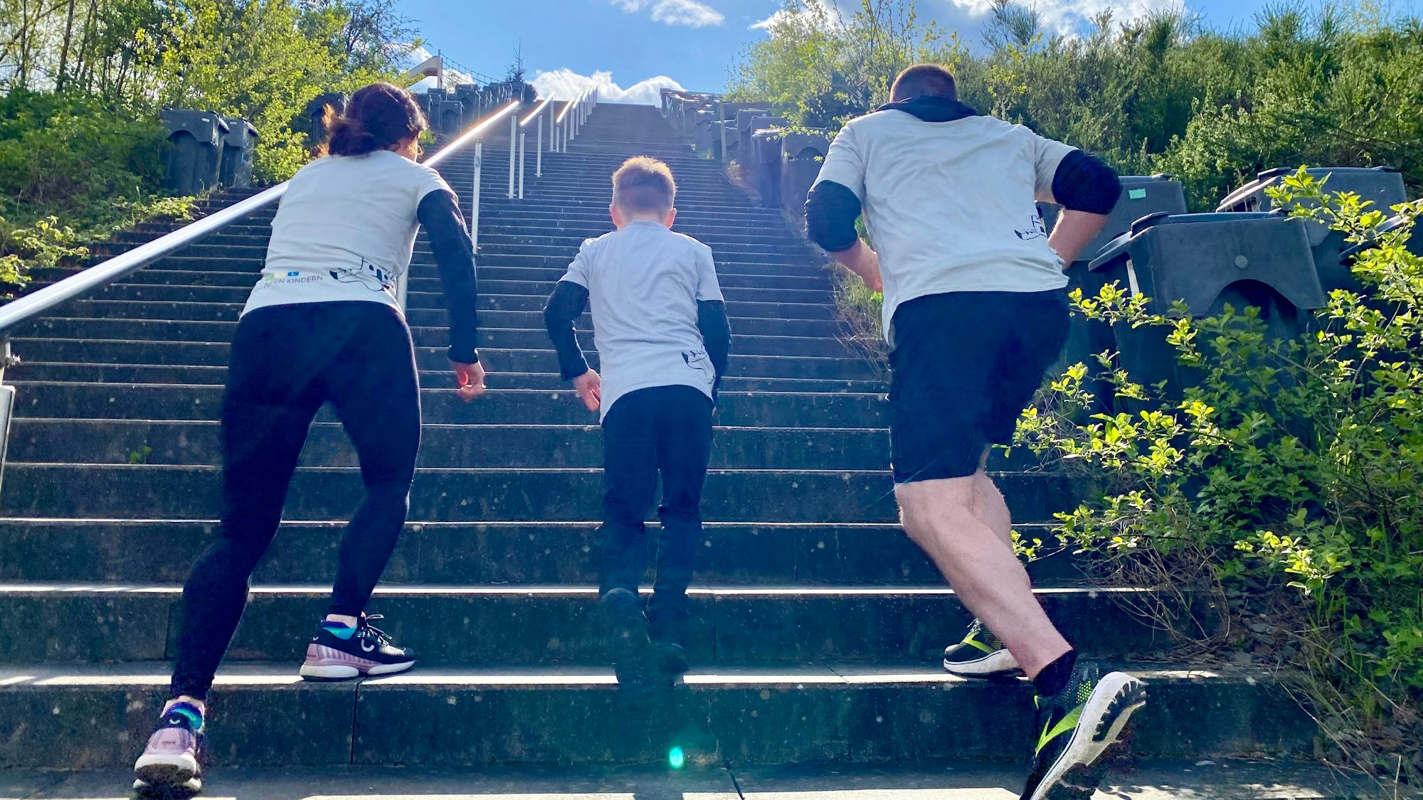 Leon Barth und seine Eltern Stefanie und Marc laufen eine Treppe hinauf.