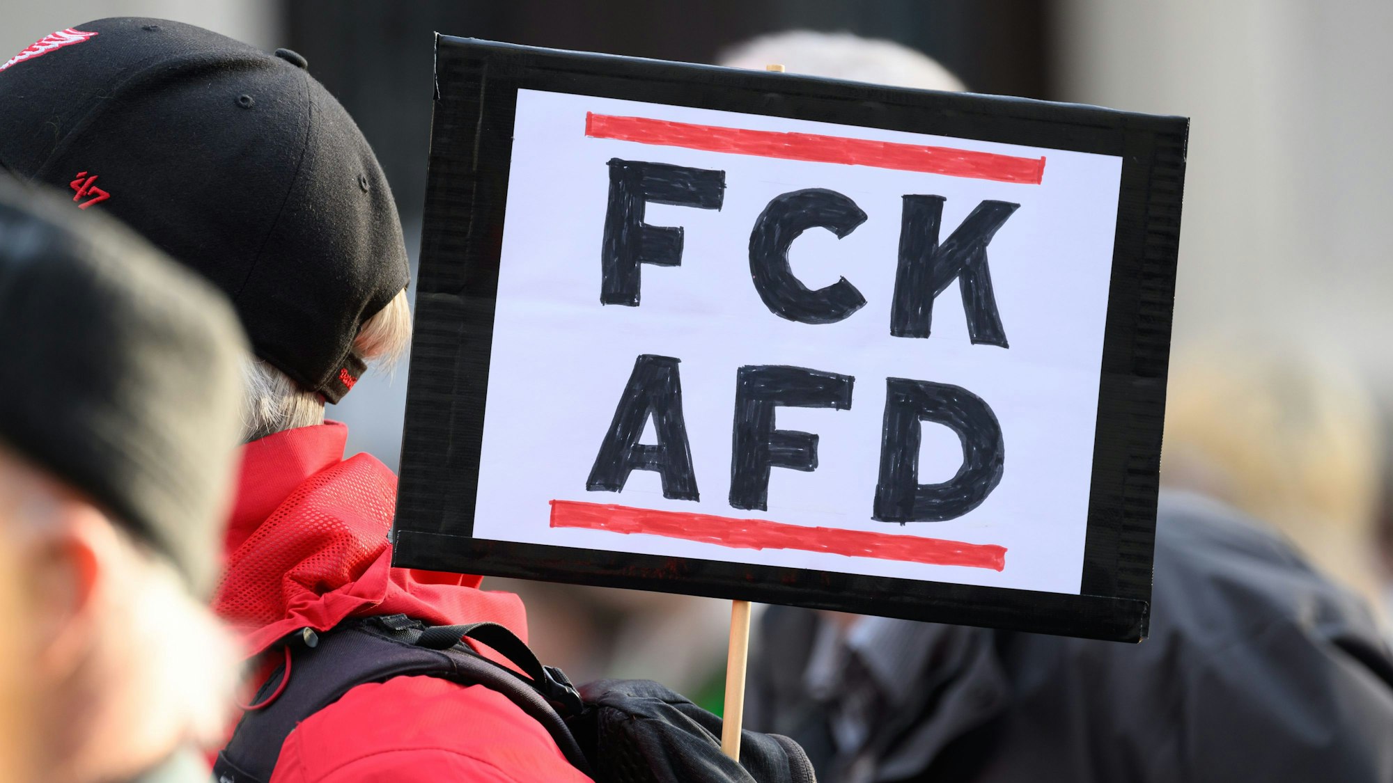 ARCHIV - 26.03.2024, Sachsen, Pirna: Ein Teilnehmer einer Demonstration vom Aktionsbündnis «Pirna ist bunt» unter dem Motto «Alle zusammen für Solidarität und Offenheit» steht mit eine Schild ·FCK AFD· auf dem Marktplatz.