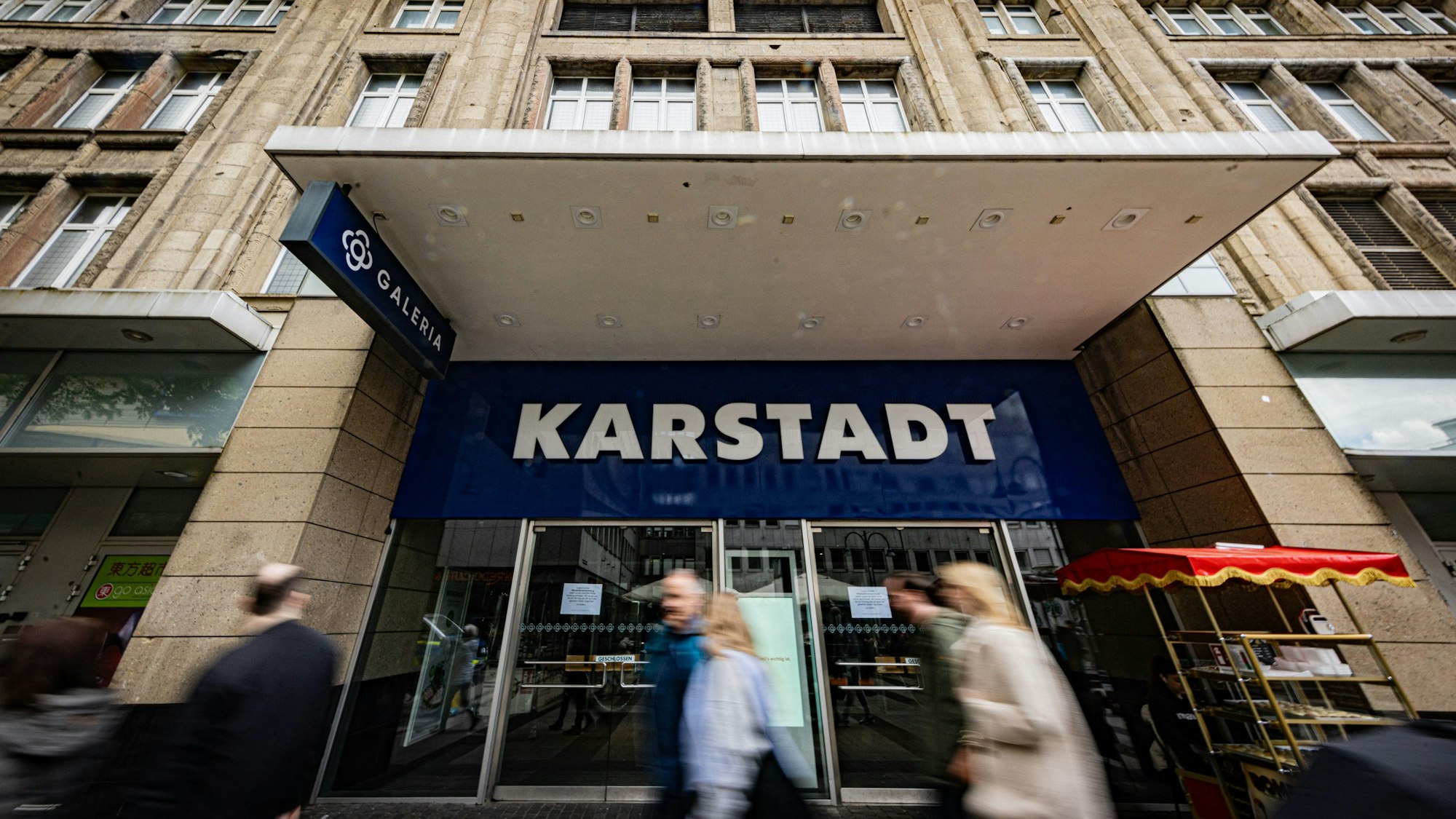 Menschen laufen an der geschlossenen Filiale von Galeria Karstadt Kaufhof an der Breite Straße vorbei.