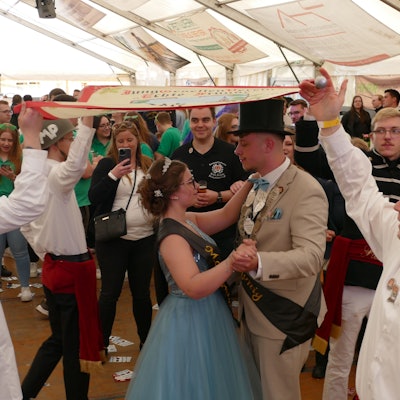 Ein Paar tanzt unter einer Fahne.