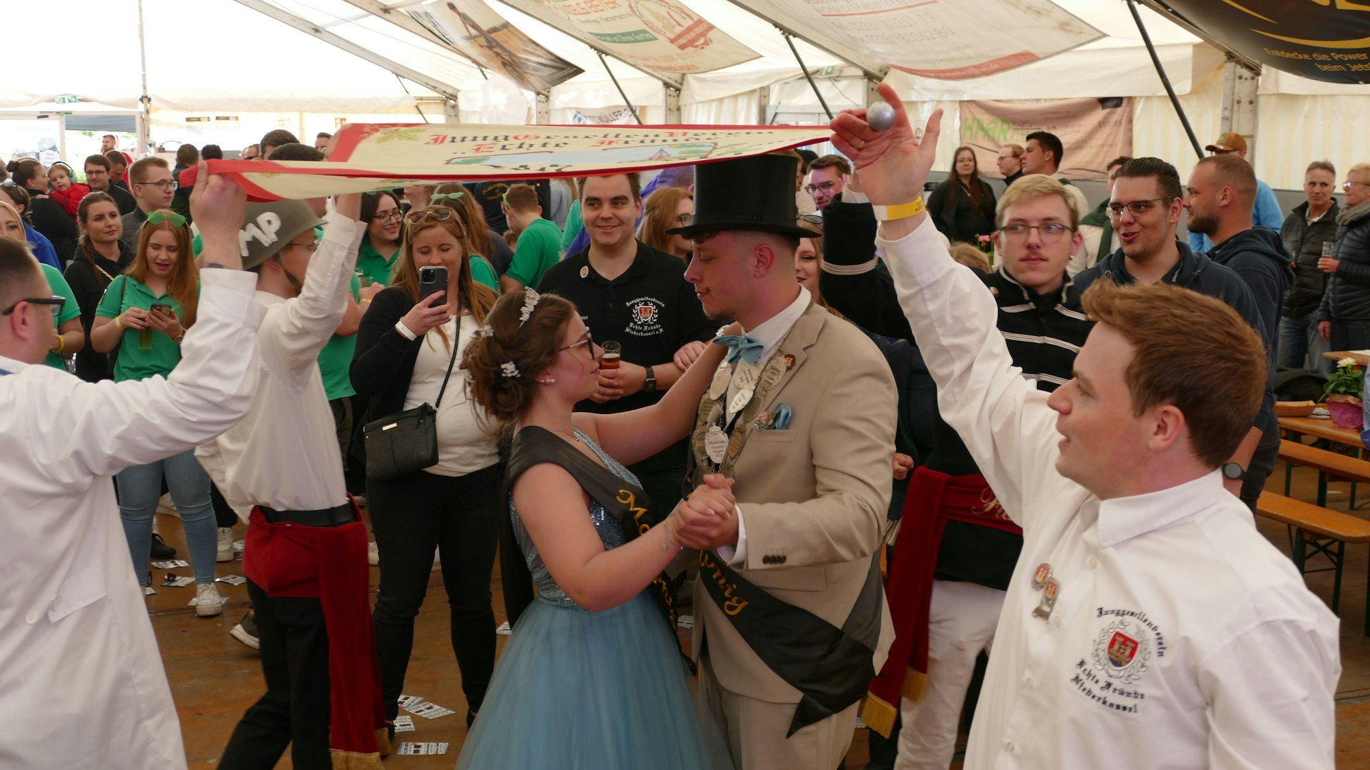 Ein Paar tanzt unter einer Fahne.