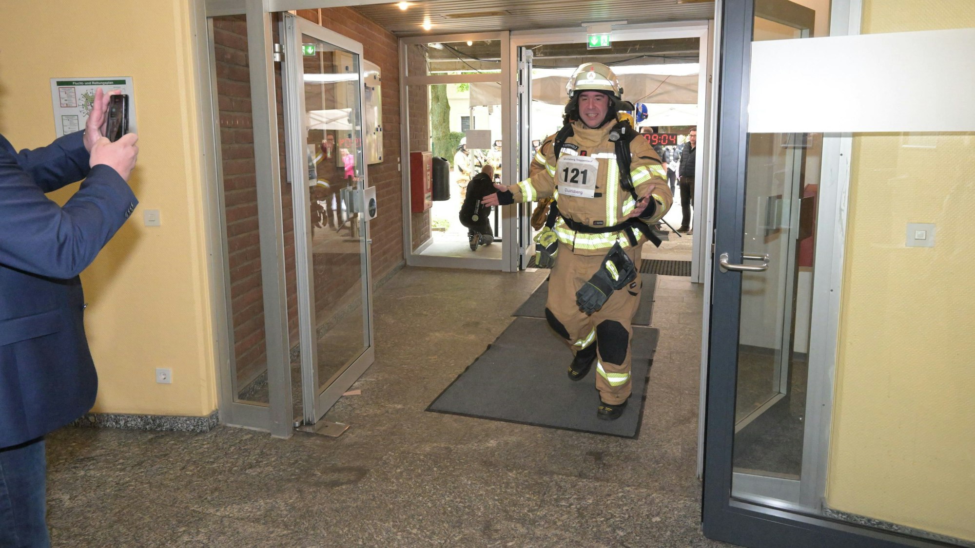 Ein Feuerwehrmann läuft in voller Schutzkleidung ins Treppenhaus.