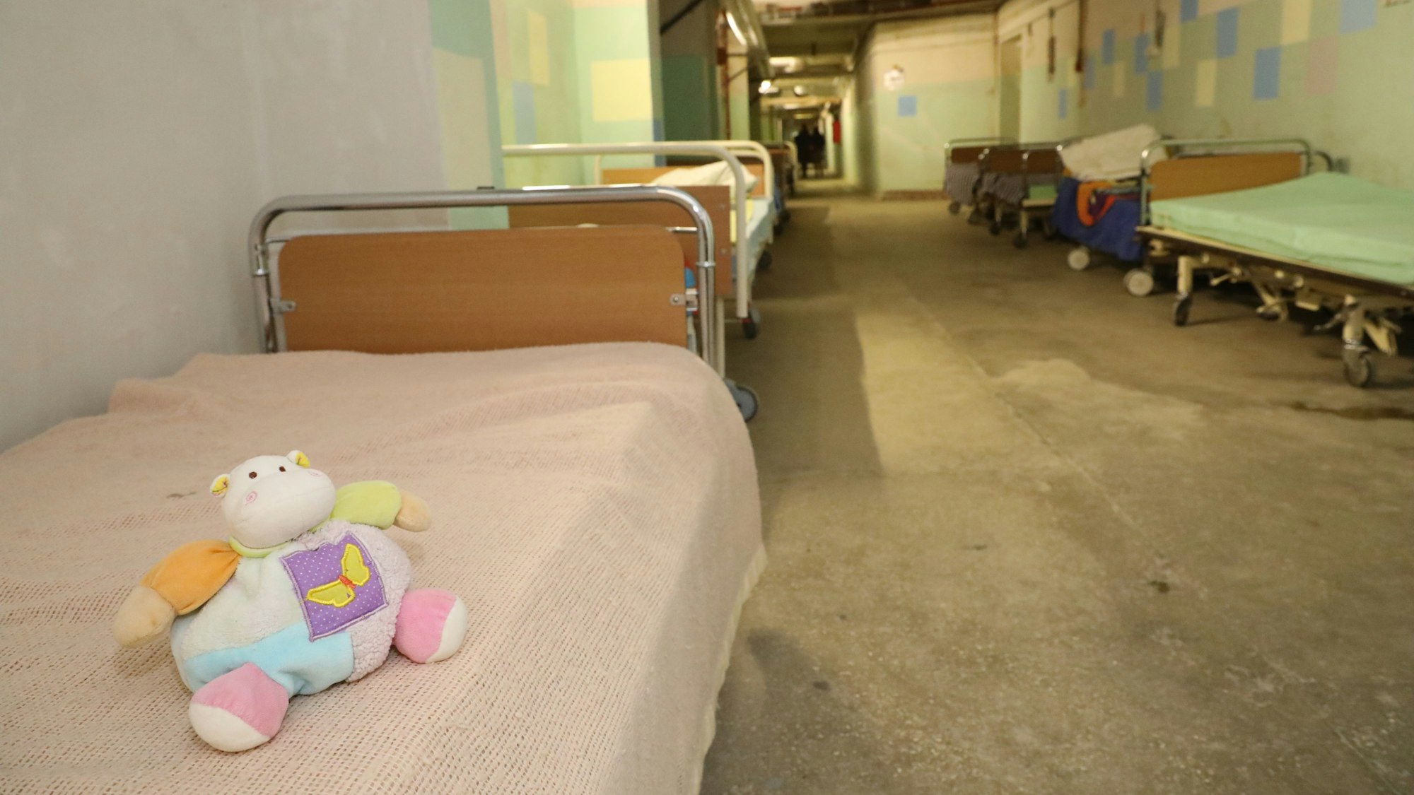 Ein Kuscheltier liegt auf einem Krankenbett im Luftschutzbunker der Kinderklinik Lviv.