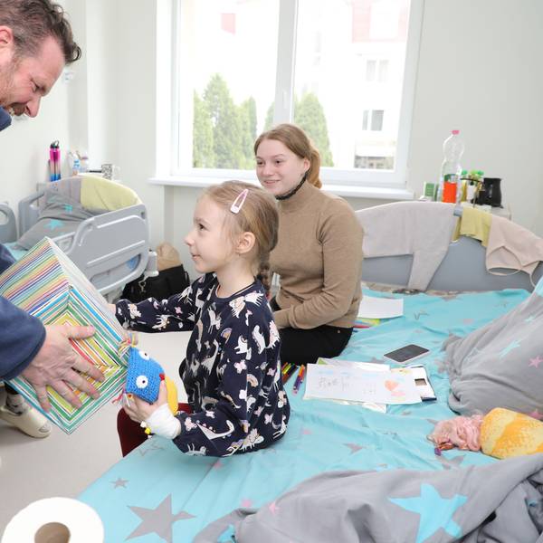 Thomas Migenda von der Humanitären Hilfe Overath überreicht einem Kind in der Kinderklinik Lviv ein Geschenk.