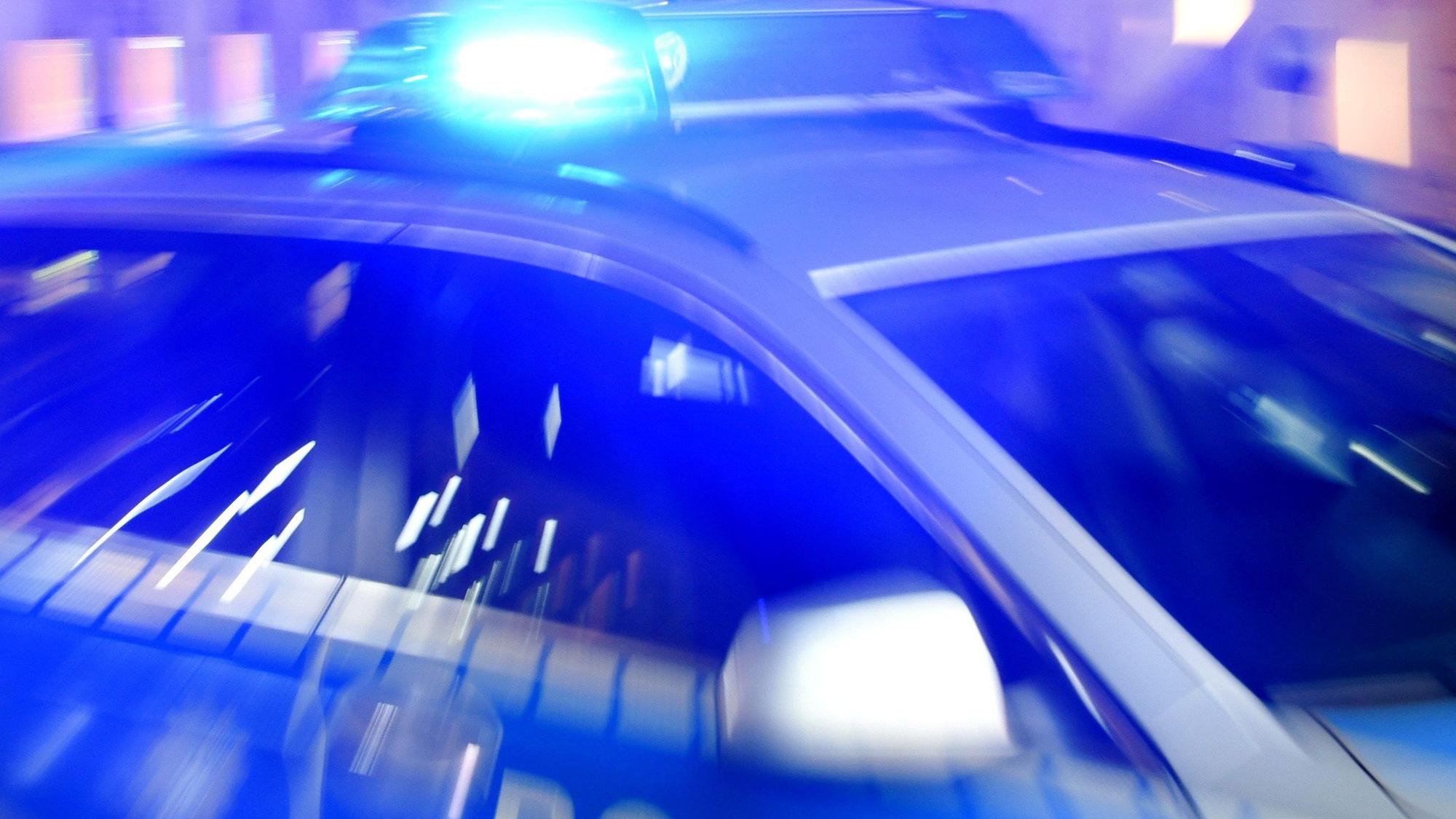 Ein Streifenwagen der Polizei steht mit eingeschaltetem Blaulicht auf der Straße. (Symbolbild)