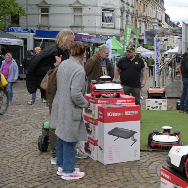 Interessierte stehen an einem Stand.