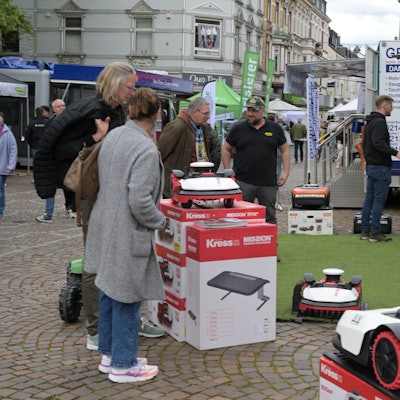 Interessierte stehen an einem Stand.