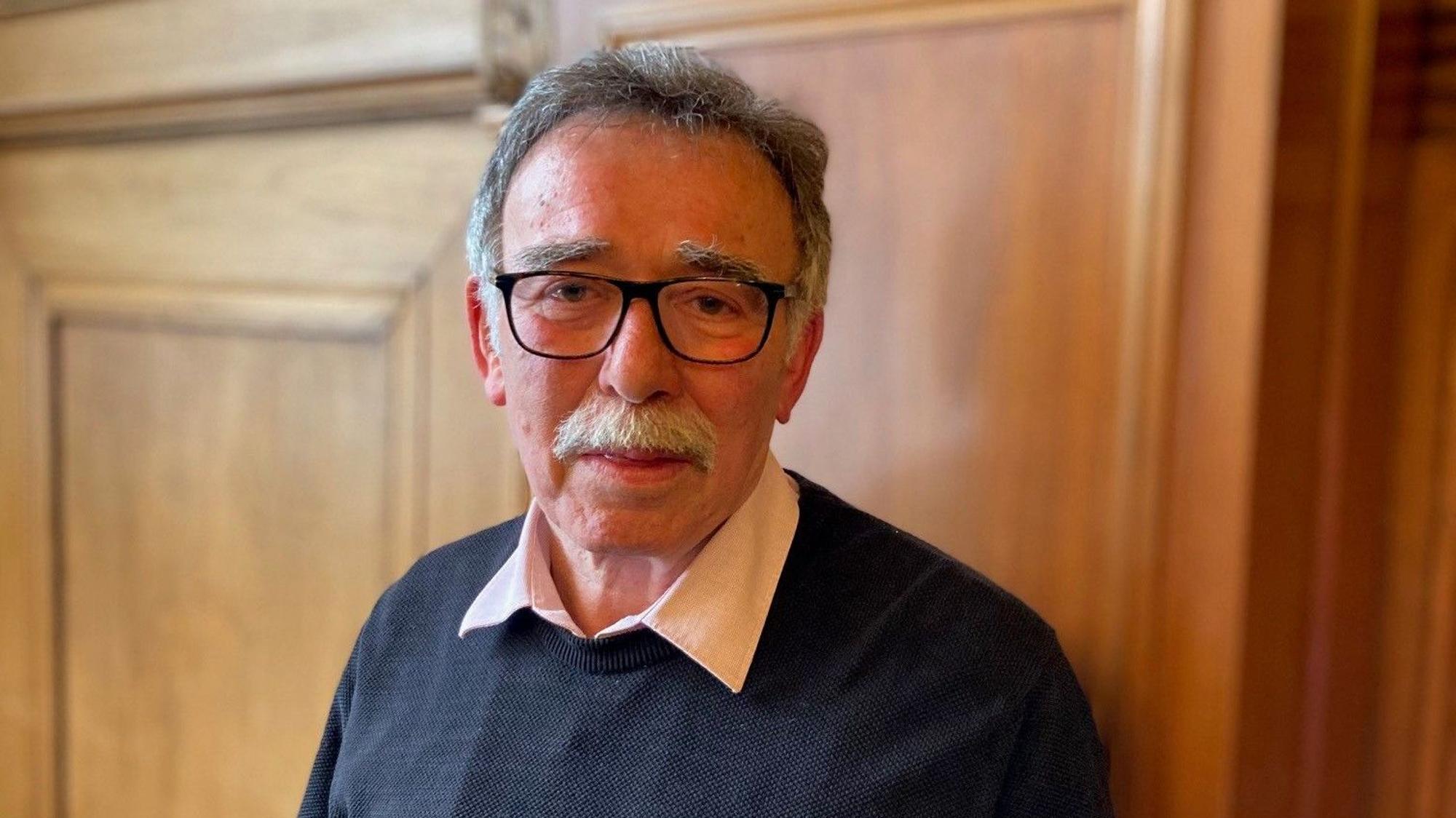 Porträtfoto des Mannes, der eine Brille trägt.