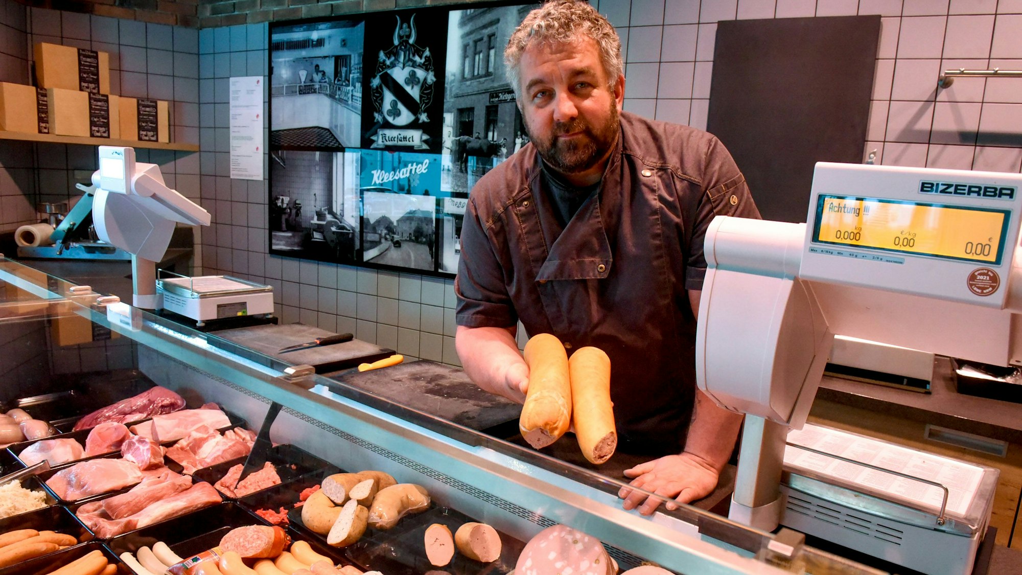 Zu sehen ist Metzger Markus Kleesattel hinter der Fleischereitheke.