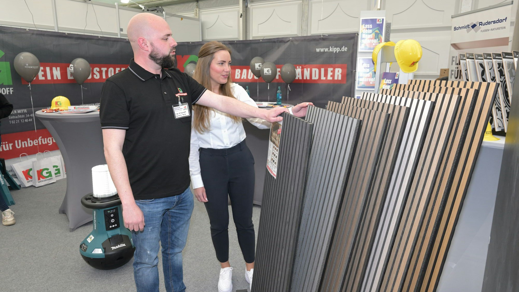 Zwei Aussteller schauen auf ihre Ware.