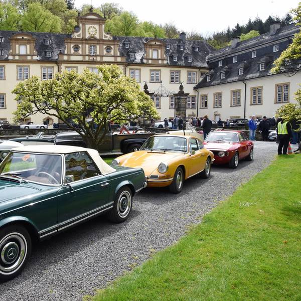 Oldtimer stehen Stoßstange an Stoßstange im Innenhof von Schloss Ehreshoven bei Engelskirchen.