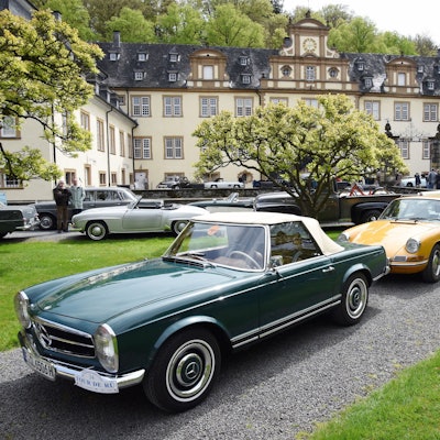 Oldtimer stehen Stoßstange an Stoßstange im Innenhof von Schloss Ehreshoven bei Engelskirchen.