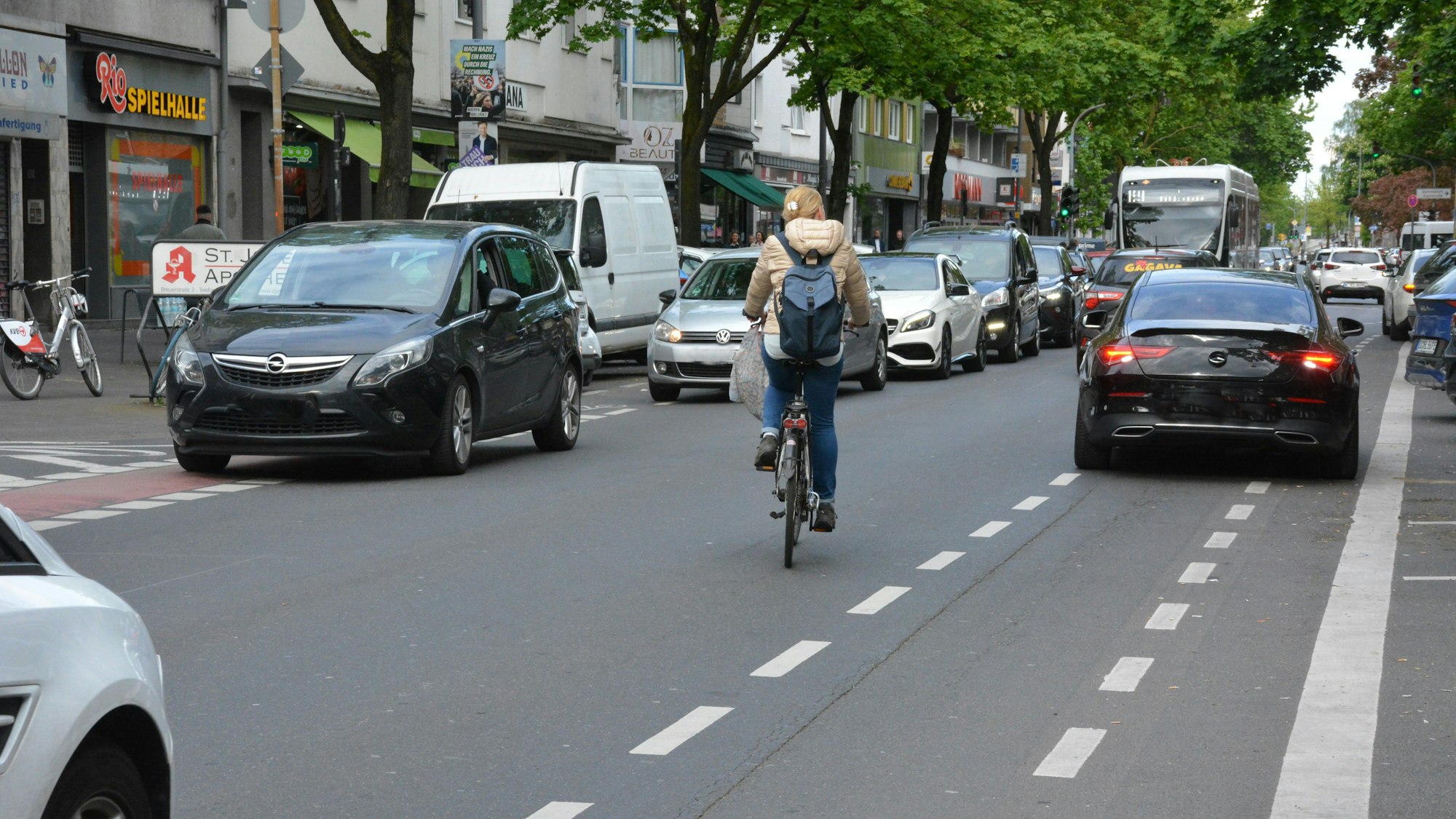 Radfahrerin weicht Autos aus, das auf der Kalker Hauptstraße auf dem Radweg parkt.