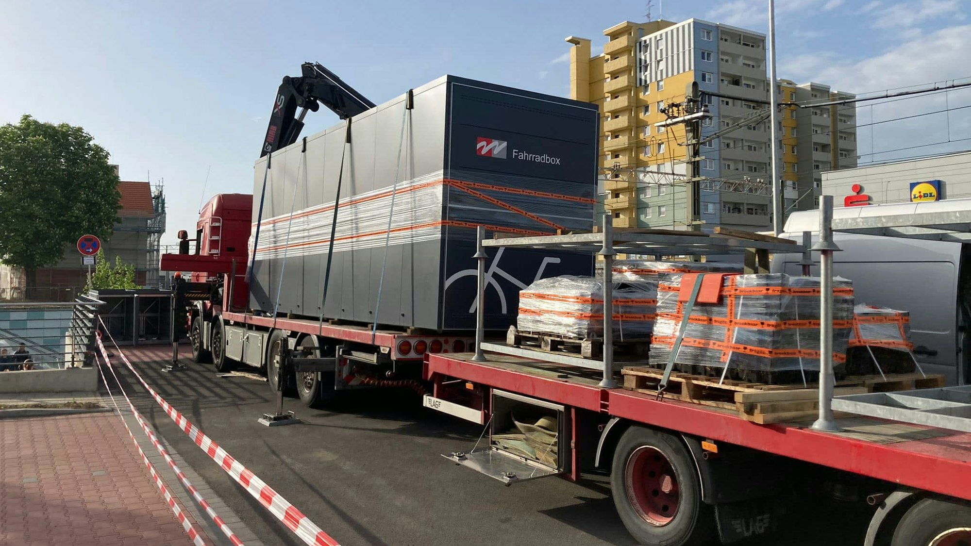 Auf dem Foto sind Schwertransporter mit den Fahrradboxen auf der Ladefläche zu sehen.