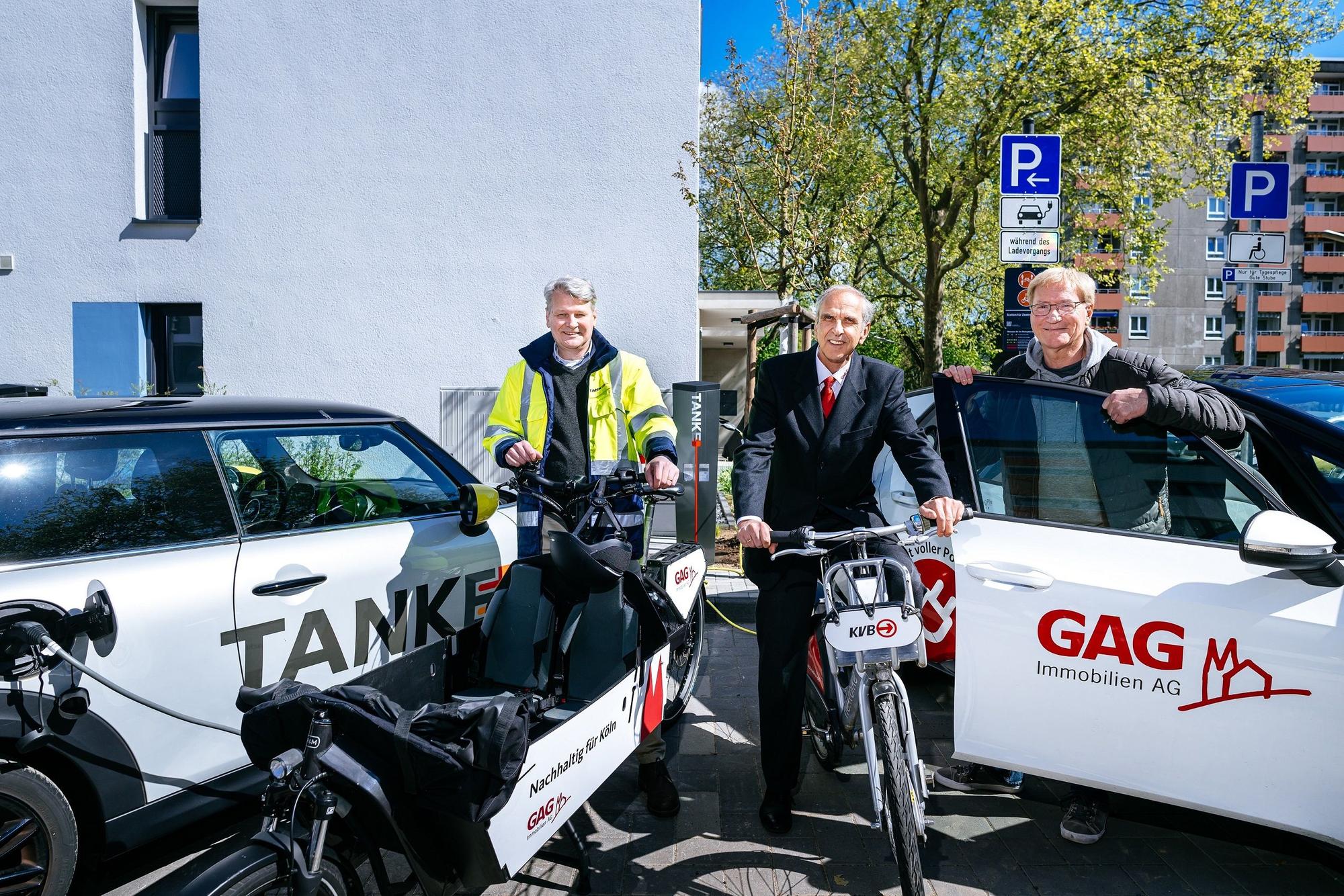 Jörn Hansen (TankE, links), Bernd Gräber (GAG, Mitte) und Frank Wendler (KVB, rechts)eröffnen den Mobilitäts-Hub mit Ladesäulen für E-Pkw, KVB-Rädern und GAG-Lastenradin der Kannebäckersiedlung in Humbold/Gremberg.