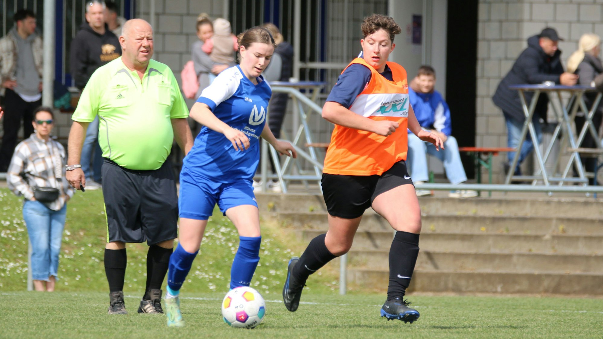 Der Schiedsrichter beobachtet ein Laufduelle zweier Spielerinnen.