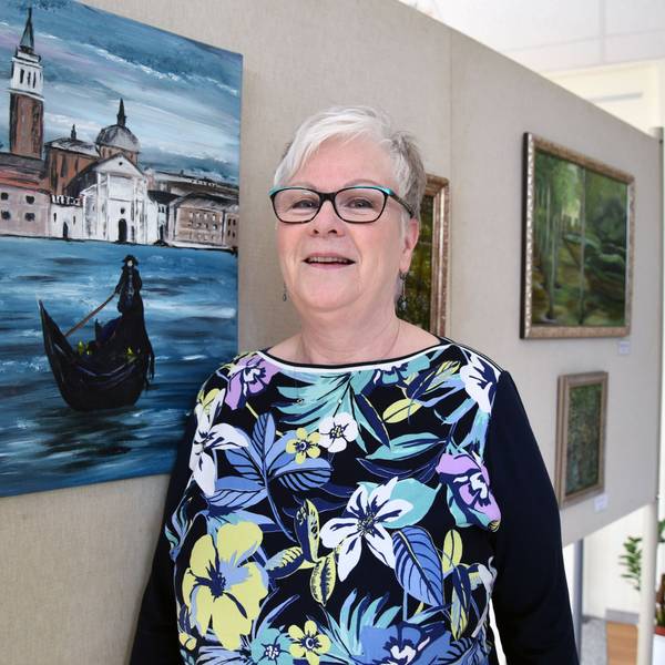 Die Künstlerin Gabriele Mückl steht vor einem Bild.
