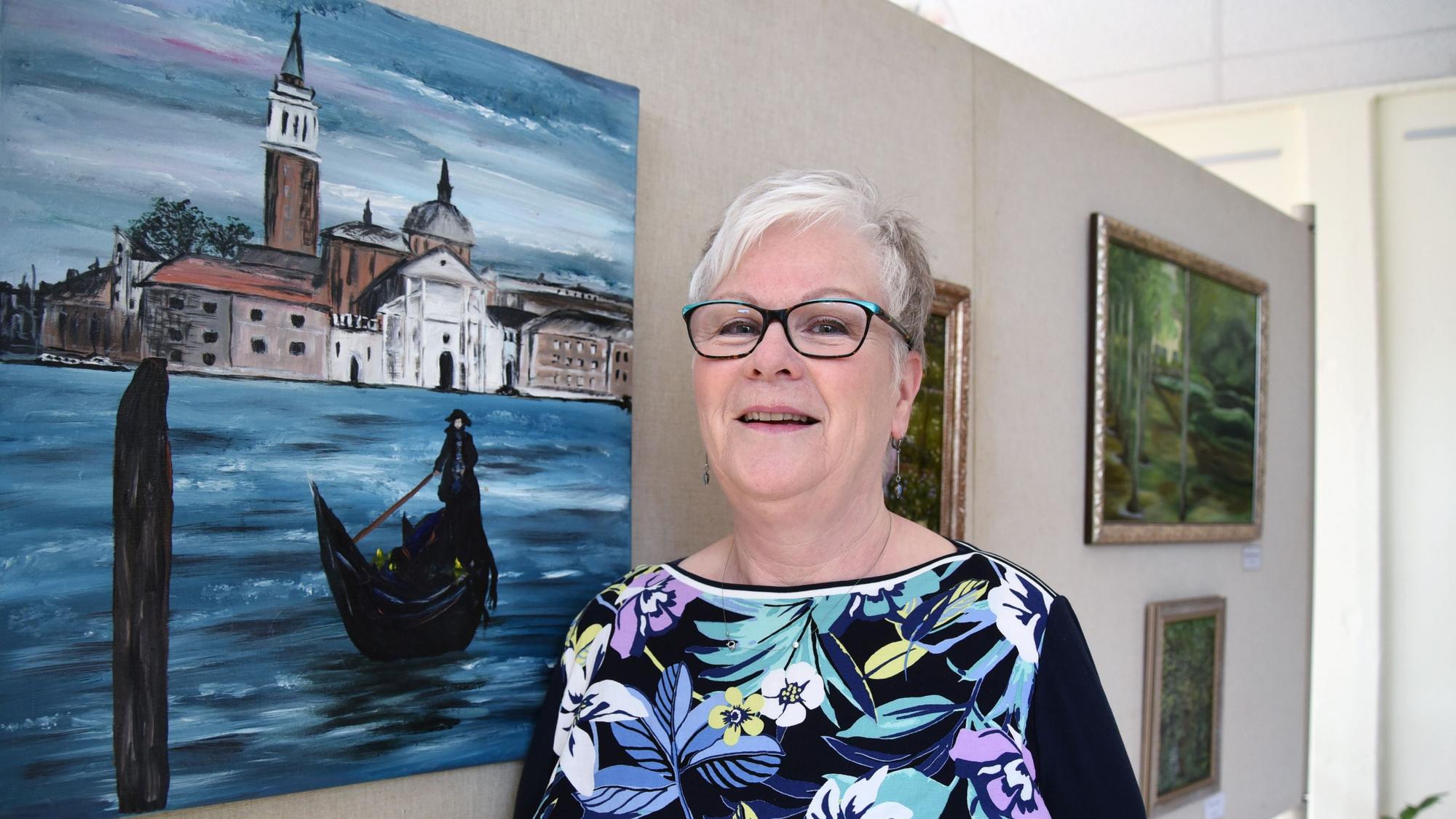 Die Künstlerin Gabriele Mückl steht vor einem Bild.