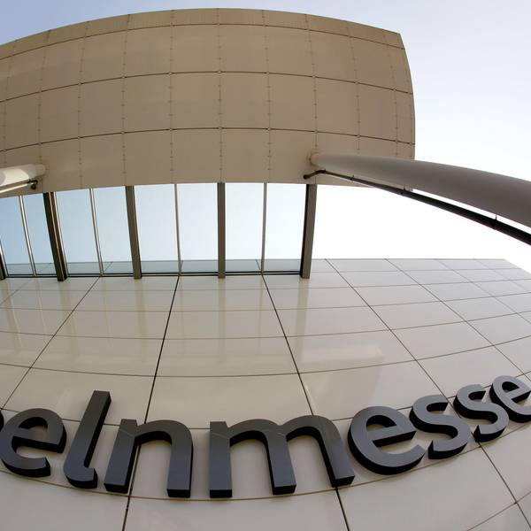 Das Logo der Kölnmesse hängt an einer Hauswand.