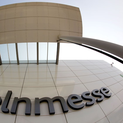 Das Logo der Kölnmesse hängt an einer Hauswand.