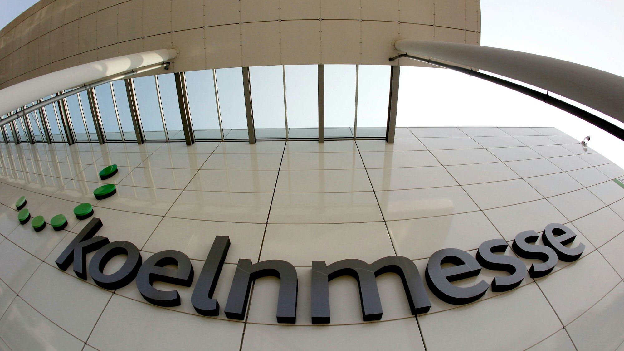 Das Logo der Kölnmesse hängt an einer Hauswand.