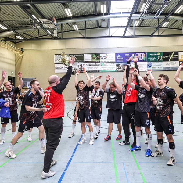 In der Mitte steht der Nümbrechter Torhüter und recht den Pokal zur Freude seiner Mansnchaftskollegen in die Höhe.