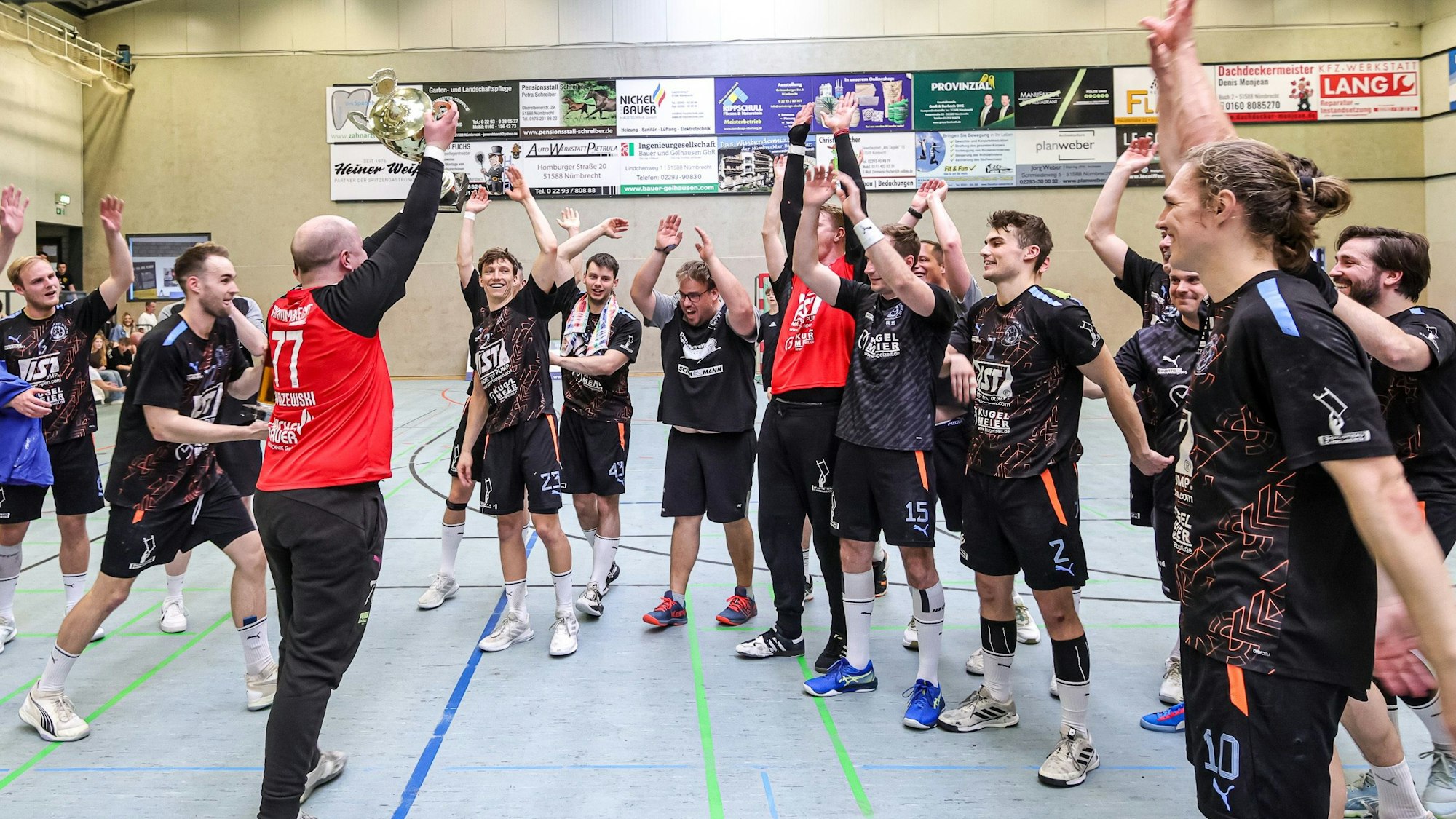In der Mitte steht der Nümbrechter Torhüter und recht den Pokal zur Freude seiner Mansnchaftskollegen in die Höhe.