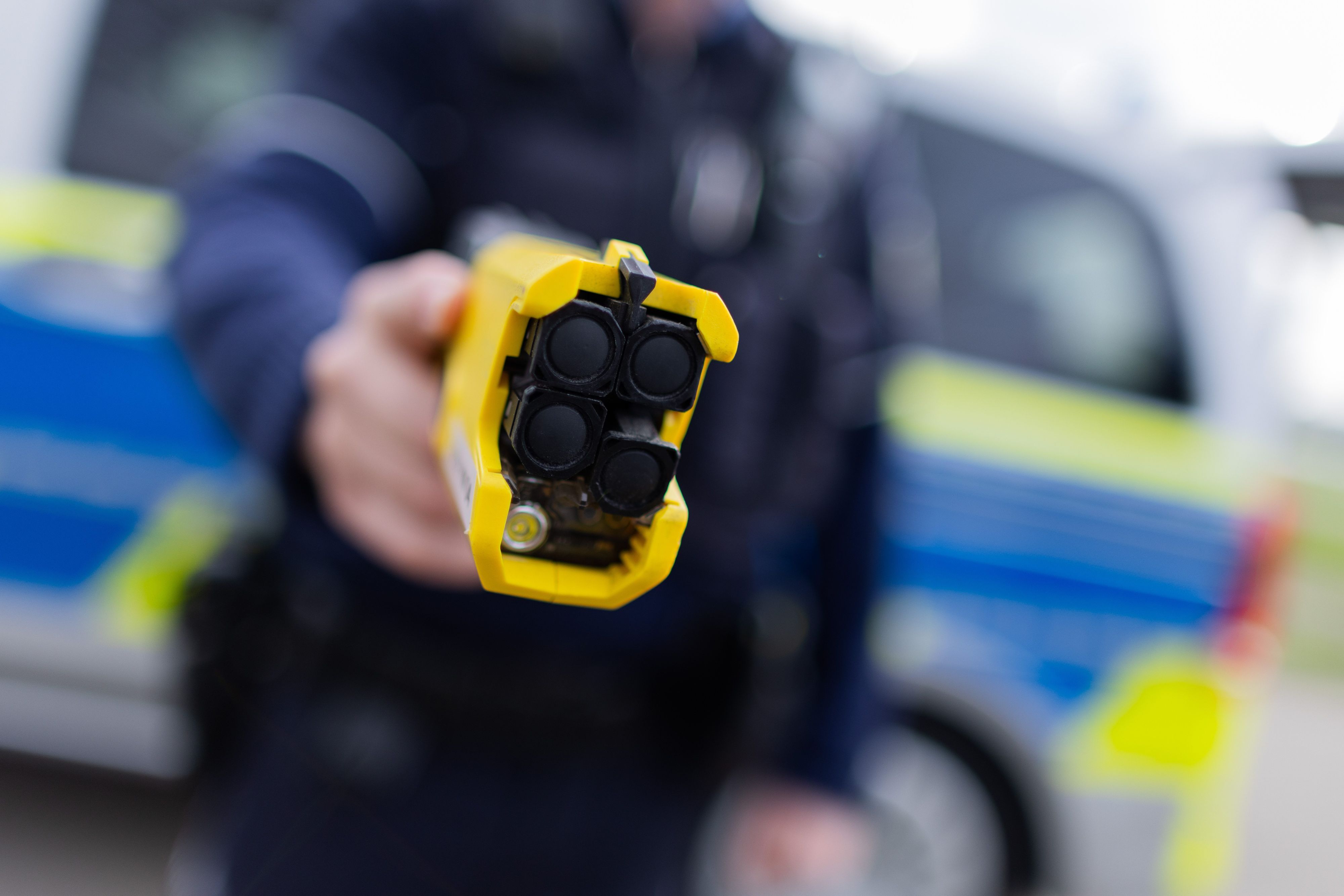 PRODUKTION - 07.03.2024, Nordrhein-Westfalen, Düsseldorf: Ein Polizist hält einen Taser (Distanzelektroimpulsgerät) in den Händen. Das Gerät sendet nach Abschuss zweier Elektroden Stromimpulse ab. (zu dpa: «Polizei greift öfter zum Taser - drückt aber selten ab») Foto: Rolf Vennenbernd/dpa +++ dpa-Bildfunk +++