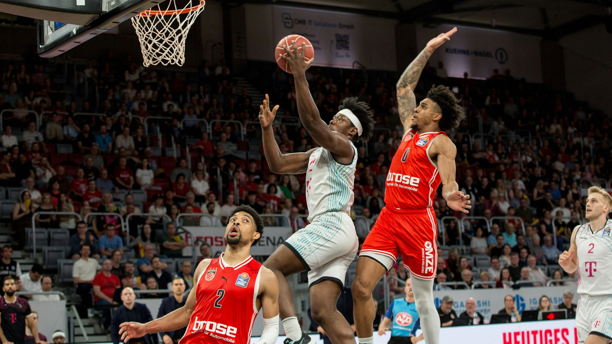 Brian Fobbs (M.) stürmt an Justin Gray (r.) und Zach Copeland vorbei zum Bamberger Korb.