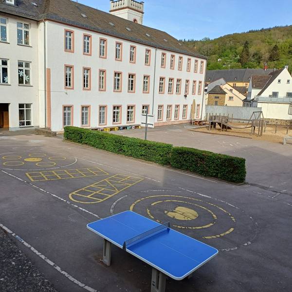 Das Bild zeigt den Blick auf die Grundschule mit dem Schulhof im Vordergrund.