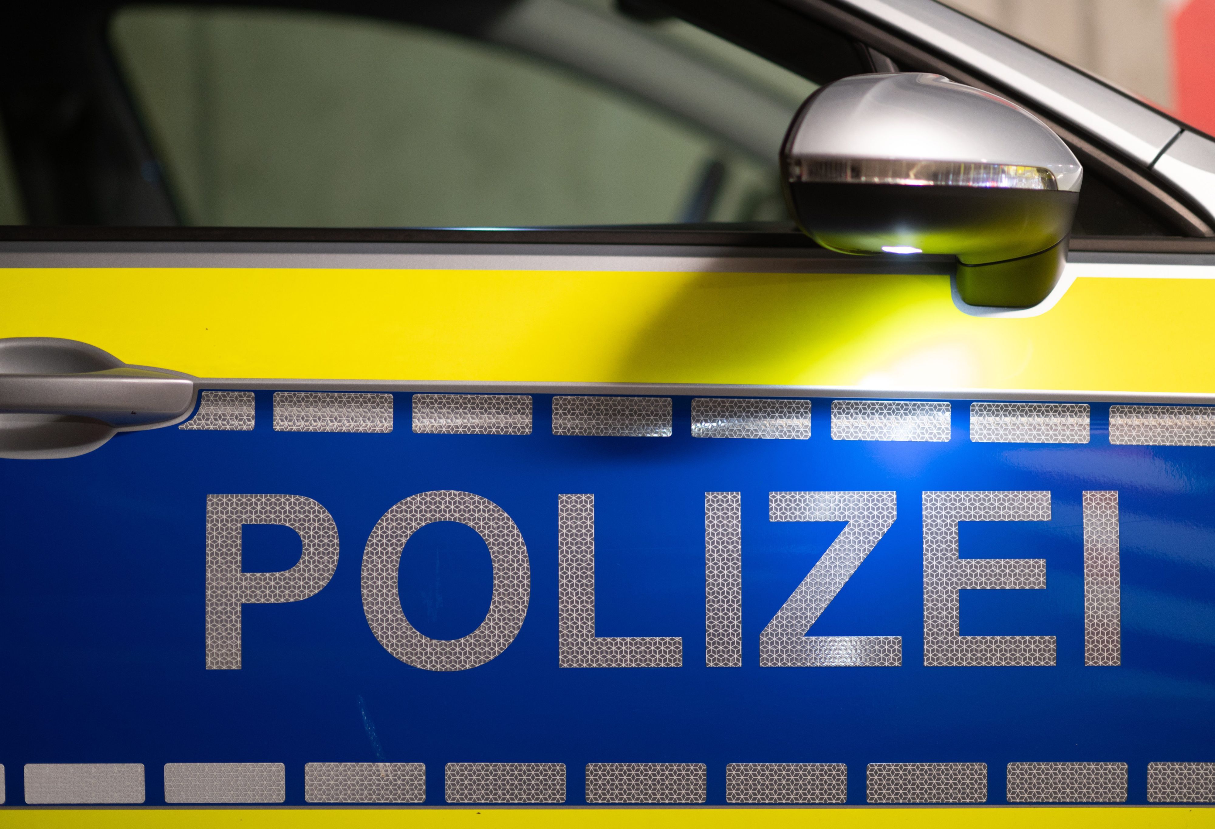 Polizei· ist auf der Tür eines Polizeiautos zu lesen.