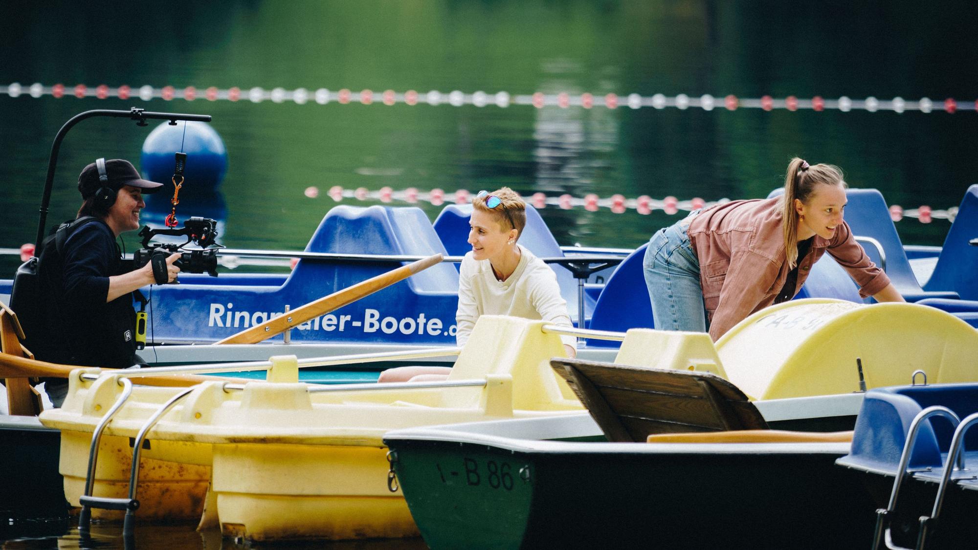 Eine Kamerafrau filmt Eva Pinkelnig und Katharina Schmid auf einem Boot.