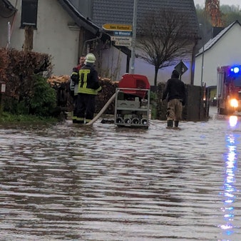 Das Bild zeigt eine überflutete Straße in Schmidtheim. Die Feuerwehr pumpt das Wasser ab.