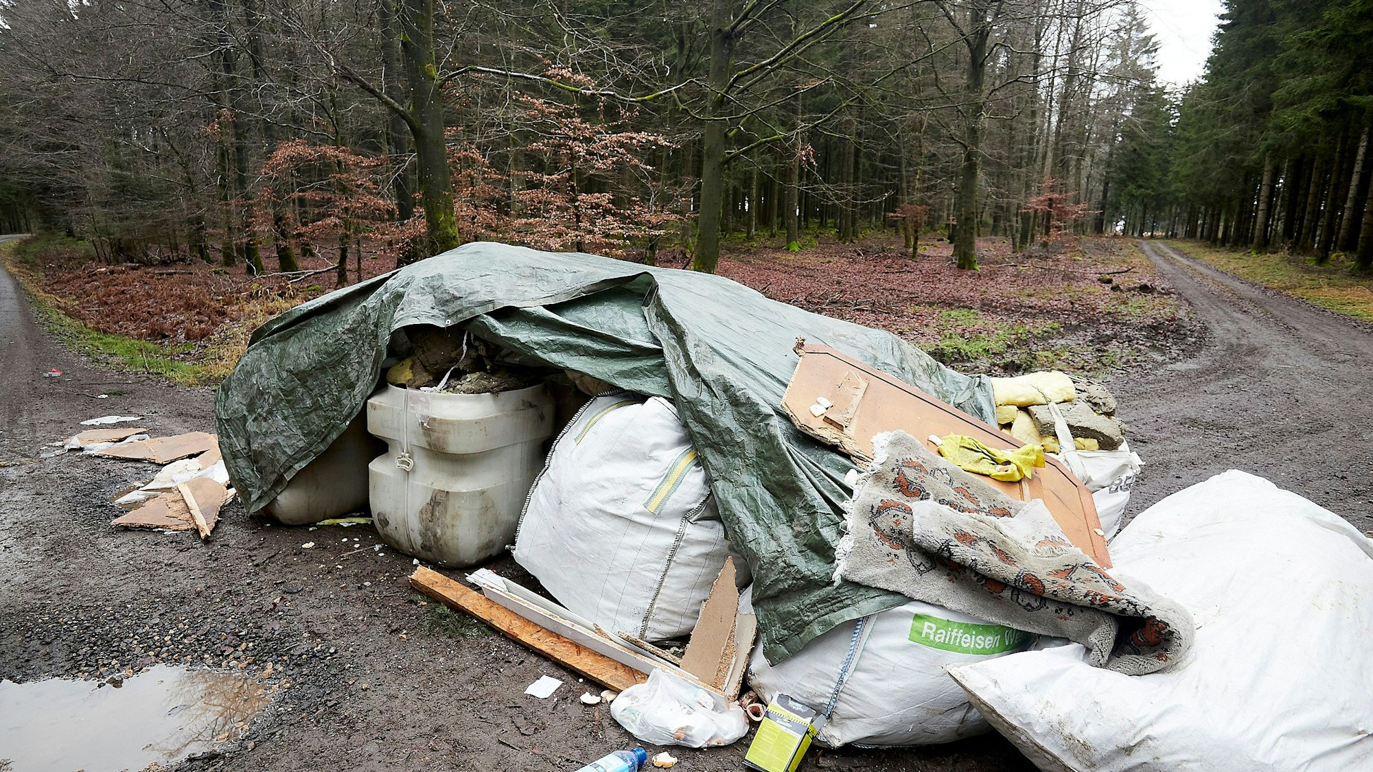 Ein Berg Abfall auf einem Waldweg.