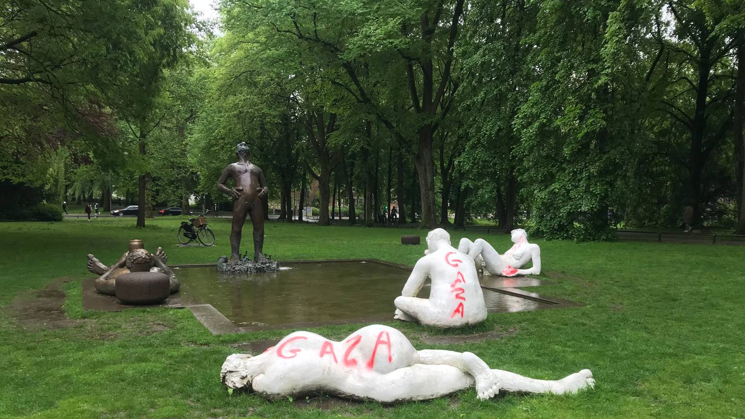 Statuen bei einem Teich umgeben von Bäumen sind beschmiert worden.