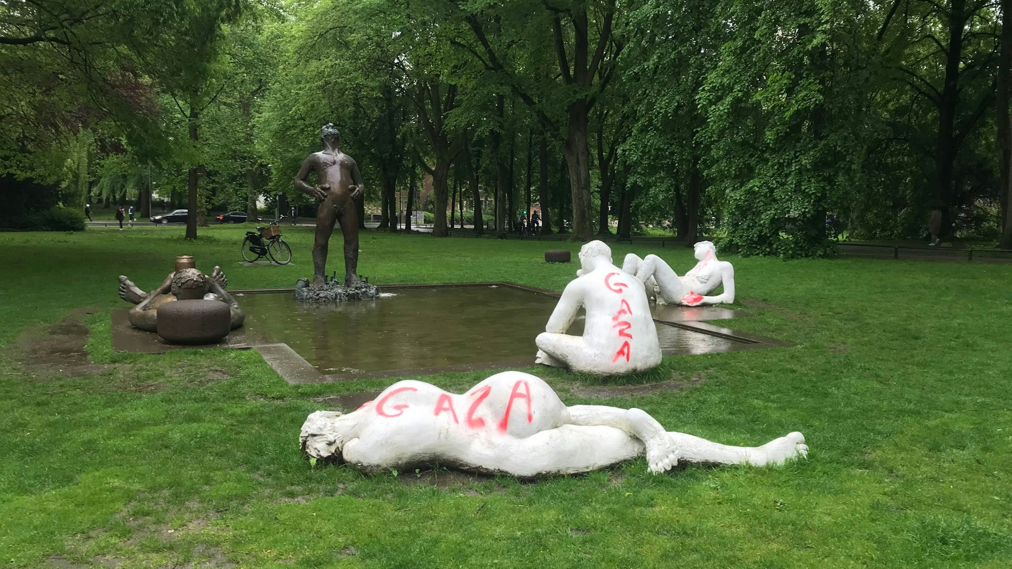 Statuen bei einem Teich umgeben von Bäumen sind beschmiert worden.